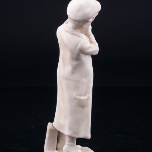 Статуэтка из фарфора Мальчик, прикуривающий на ветру, Unger, Schneider & Cie, Германия, пер. пол. 20 в.